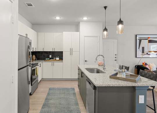 A modern kitchen with a large island and stainless steel appliances. at Bridge at Tech Crossing, Austin, Texas