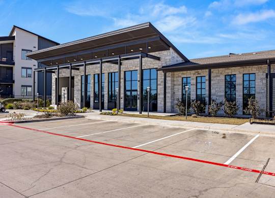 A parking lot with a building in the background. at Bridge at Tech Crossing, Austin, TX, 78753