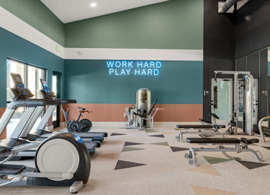 A gym with a variety of equipment including treadmills, stationary bikes, and weight machines. at Bridge at Tech Crossing, Austin