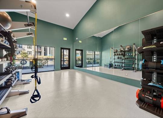 A gym with a green wall and a black and orange exercise bike. at Bridge at Tech Crossing, Austin