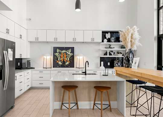 A modern kitchen with a large island and bar stools. at Bridge at Tech Crossing, Austin, TX, 78753