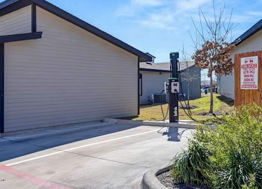 A parking lot with a building and a sign on the right. at Bridge at Tech Crossing, Austin, 78753