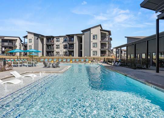 A large swimming pool in front of apartment buildings. at Bridge at Tech Crossing, Texas