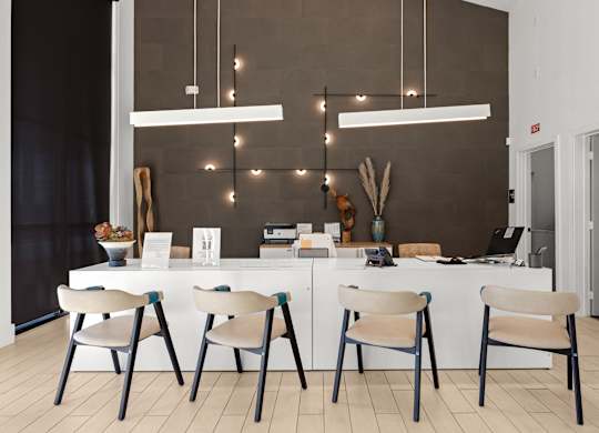 A modern kitchen with a white table and chairs. at Bridge at Tech Crossing, Texas