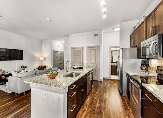 A modern kitchen with wooden floors and stainless steel appliances. at The Royce at 8100, Austin, TX, 78729
