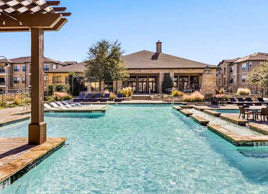 A large swimming pool with a wooden pergola over it. at The Royce at 8100, Texas, 78729