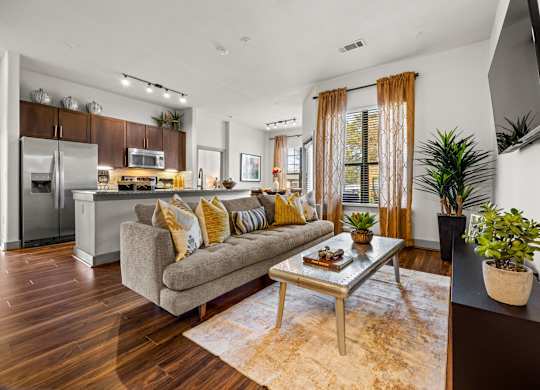 A modern living room with a grey couch and a wooden floor. at The Royce at 8100, Austin