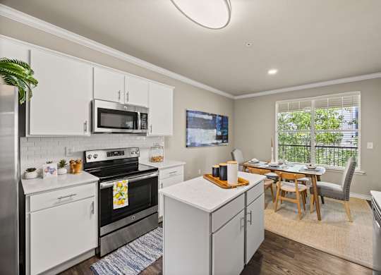 A kitchen with white cabinets and a black stove top oven. at Bridge at Canyon Creek, Austin, Texas