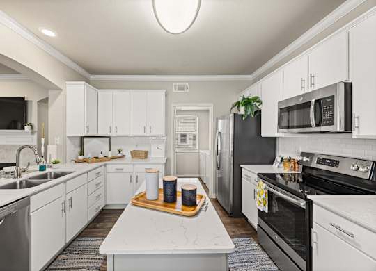 A modern kitchen with white cabinets and stainless steel appliances. at Bridge at Canyon Creek, Austin, 78726