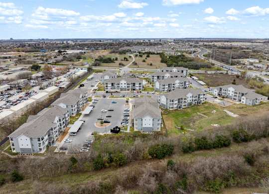 A large apartment complex with a parking lot in the foreground.