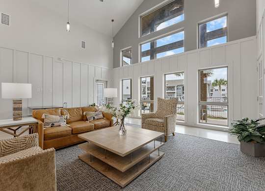 A living room with a brown couch, a wooden coffee table, and a grey carpet.