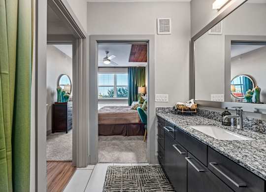 A bathroom with a green curtain and a mirror above the sink. at Bridge at Henley, Texas