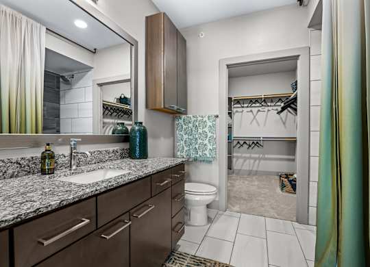A bathroom with a sink, mirror, and toilet. at Bridge at Henley, Austin, TX, 78741