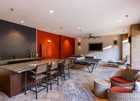 A modern kitchen with a bar area and seating. at Bridge at Henley, Austin, TX