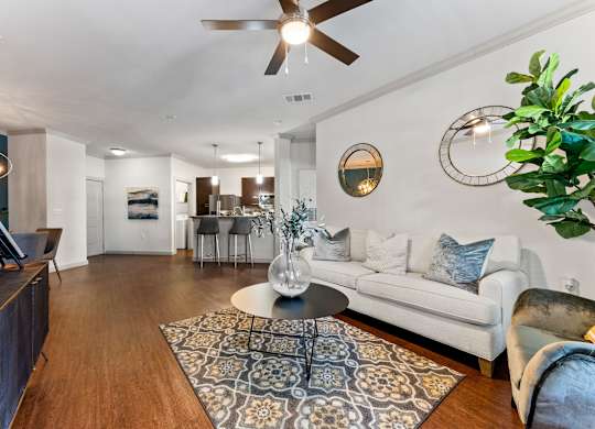 A living room with a white couch and a wooden floor. at Bridge at Indigo, Austin, TX, 78717