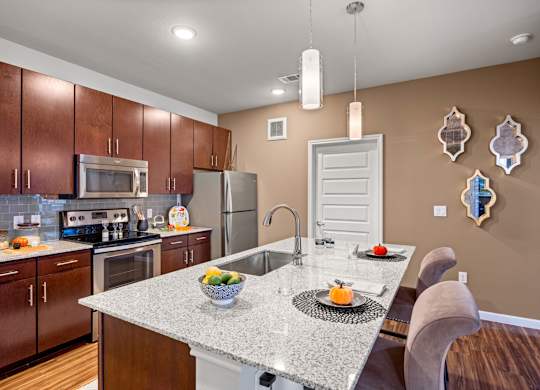 A kitchen with brown cabinets and a granite countertop. at Bridge at Southpark Meadows, Texas, 78748