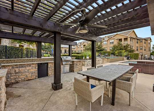 A patio with a table and chairs under a pergola. at The James on South First, Austin, 78748