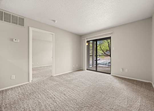 A room with a carpeted floor and a sliding glass door leading outside. at Montecito, Austin, TX, 78741