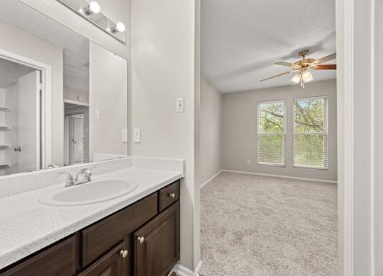 A bathroom with a sink, mirror, and a ceiling fan. at Montecito, Texas