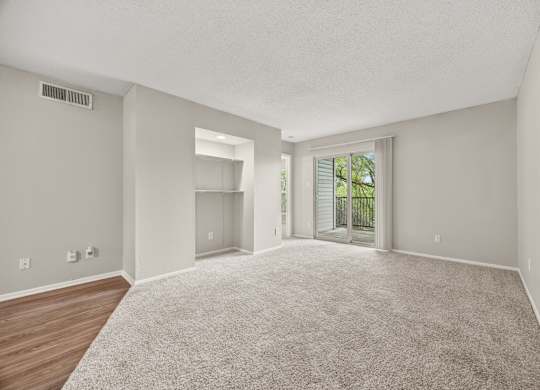 A spacious room with a carpeted floor and a sliding glass door leading to a balcony. at Montecito, Austin, TX, 78741