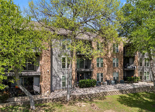 A large building with a balcony and a tree in front of it. at Montecito, Texas, 78741