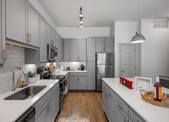 A modern kitchen with a white countertop and grey cabinets. at The Haywood Apartments, Austin, TX, 78748