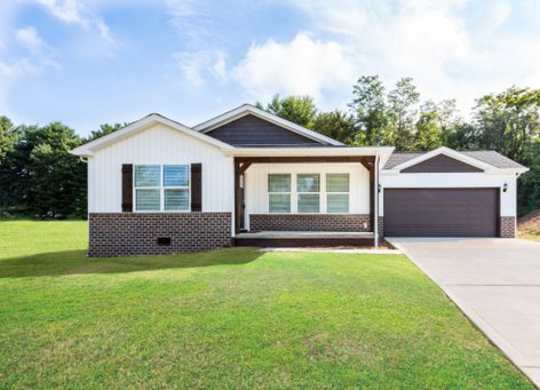 a house with a garage and a green lawn