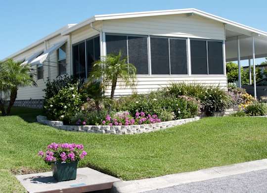 a house with a lawn and flowers in front of it
