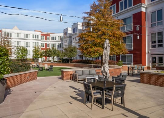 A patio with a table and chairs is surrounded by buildings.