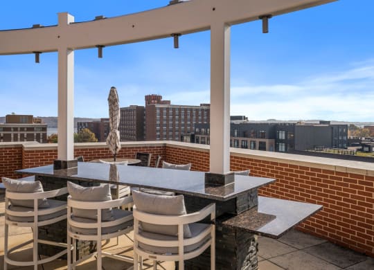 a patio with a table and chairs on top of a roof