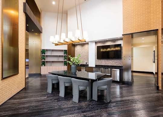 Image showing meet, mingle, and unwind. A modern communal table sits beneath warm, ambient lighting.