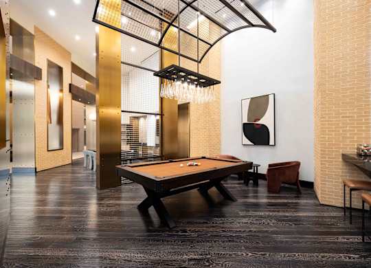 Image showing game night, upgraded. A statement pool table under striking architectural lighting.