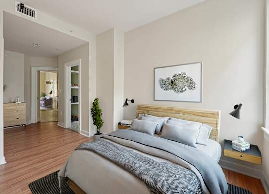 A bedroom with a large bed and a painting on the wall.