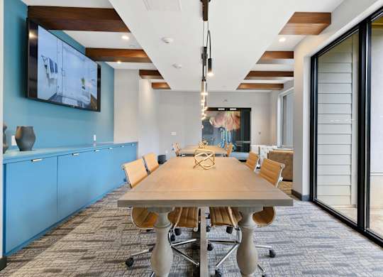 A conference room with a long table and chairs.
