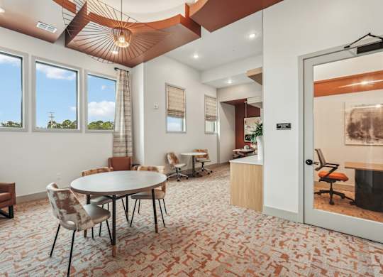 Co-working room with communal table and private coworking rooms