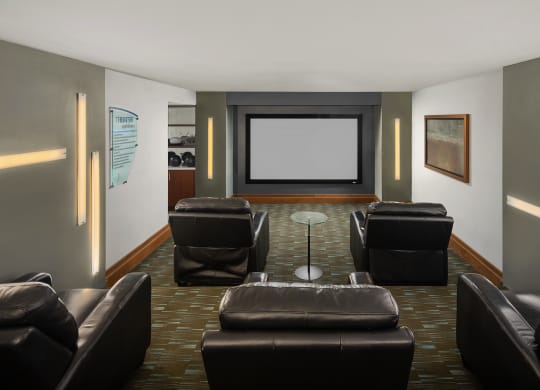 a living room with leather chairs and a projector screen