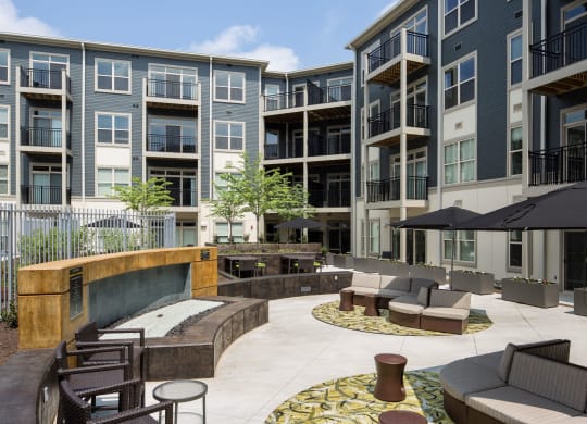 Outdoor patio with chairs and umbrellas and a building in the back and