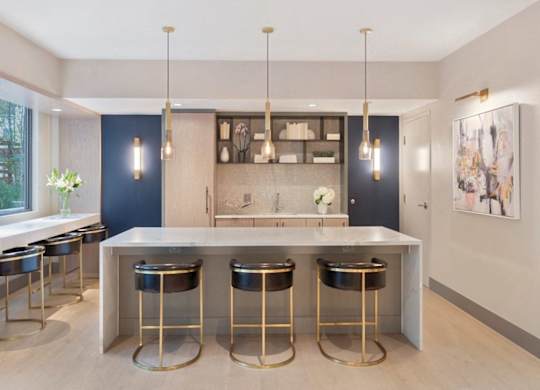 A modern kitchen with a bar area and stools.