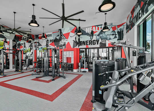 A gym with a red and white floor and a variety of equipment.