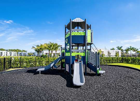 A playground with a blue slide and a white slide.