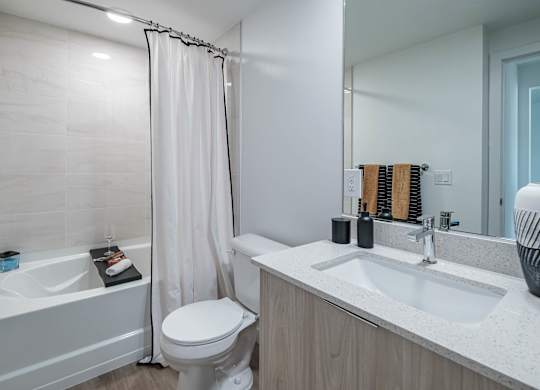 A white bathroom with a toilet, sink, and bathtub.