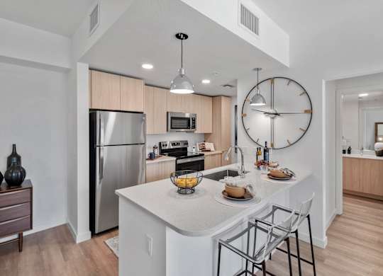 A modern kitchen with a large island and stainless steel appliances.