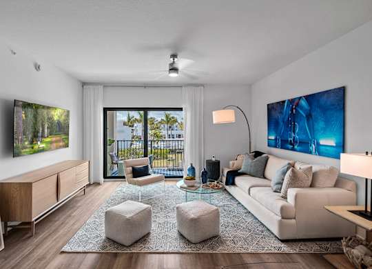 A modern living room with a large window and a painting on the wall.