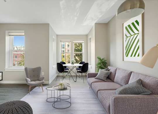 A living room with a grey couch, a white chair, a black chair, a coffee table, and a large painting on the wall.