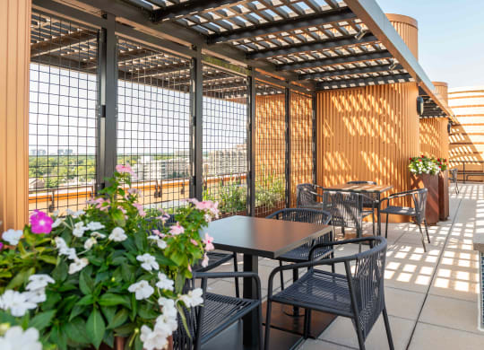 an outdoor patio with tables and chairs and a pergola