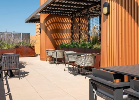 a patio with tables and chairs and a wood fence