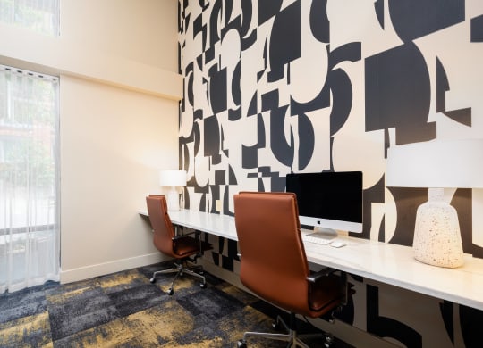 a room with two desks and two chairs and a window
