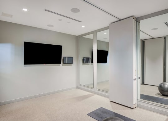 Yoga room with TV and mirrors