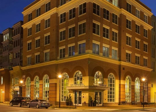 A large building with a lot of windows is lit up at night.