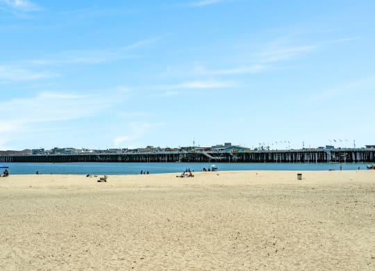 a sunny day at the beach with the pier in the water